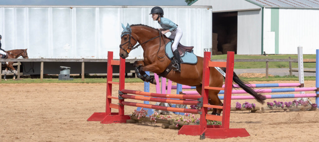 Young rider clearing a jump at a Combined Test horse show