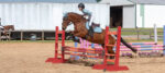 Young rider clearing a jump at a Combined Test horse show
