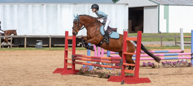 Young rider clearing a jump at a Combined Test horse show