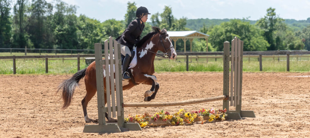 Rider clearing a jump at a Hunter horse show