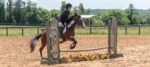 Rider clearing a jump at a Hunter horse show